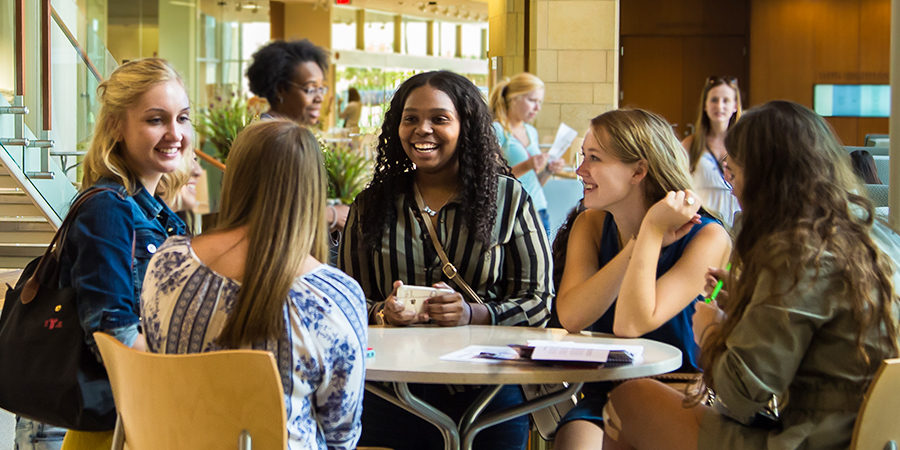 Photo of students laughing together in the Cooper Hall atrium.