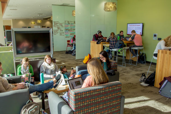 photo of students studying in groups by the windows in the Curran Commons
