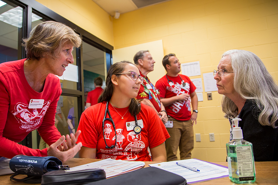 Photo of Prof. Jarzemsky working with her students to offer care to the local elderly community.