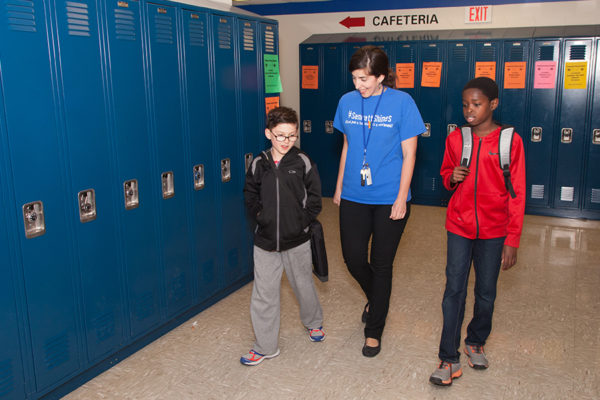 Photo of Sennett Middle School students walk the halls with their school nurse.