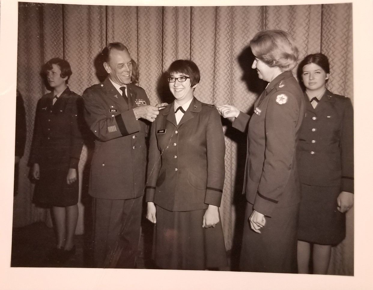 Vintage photo of Mary Jane Esser receiving rank insignia, marking her promotion to first lieutenant in the US Army Nurse Corps.