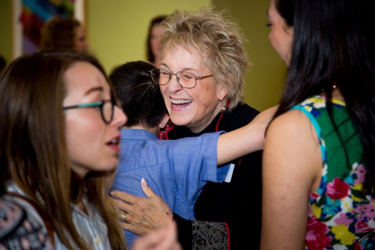 Nancy Kaufman smiling and hugging a child