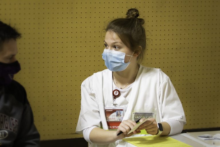 Female UW–Madison nursing student assists at a community vaccination clinic