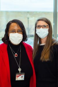 Dean Linda Scott and alumna Sarah Brzozowski pose together wearing face masks